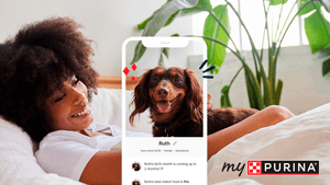 mypurina app on an iPhone with a woman and her dog on the couch in the background