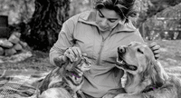 Woman petting a cat and a dog